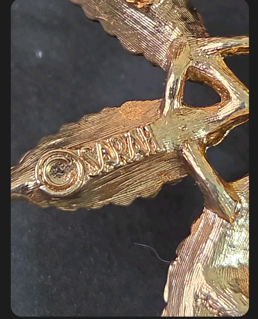 Back of a vintage Sarah Coventry brooch showing the maker's mark