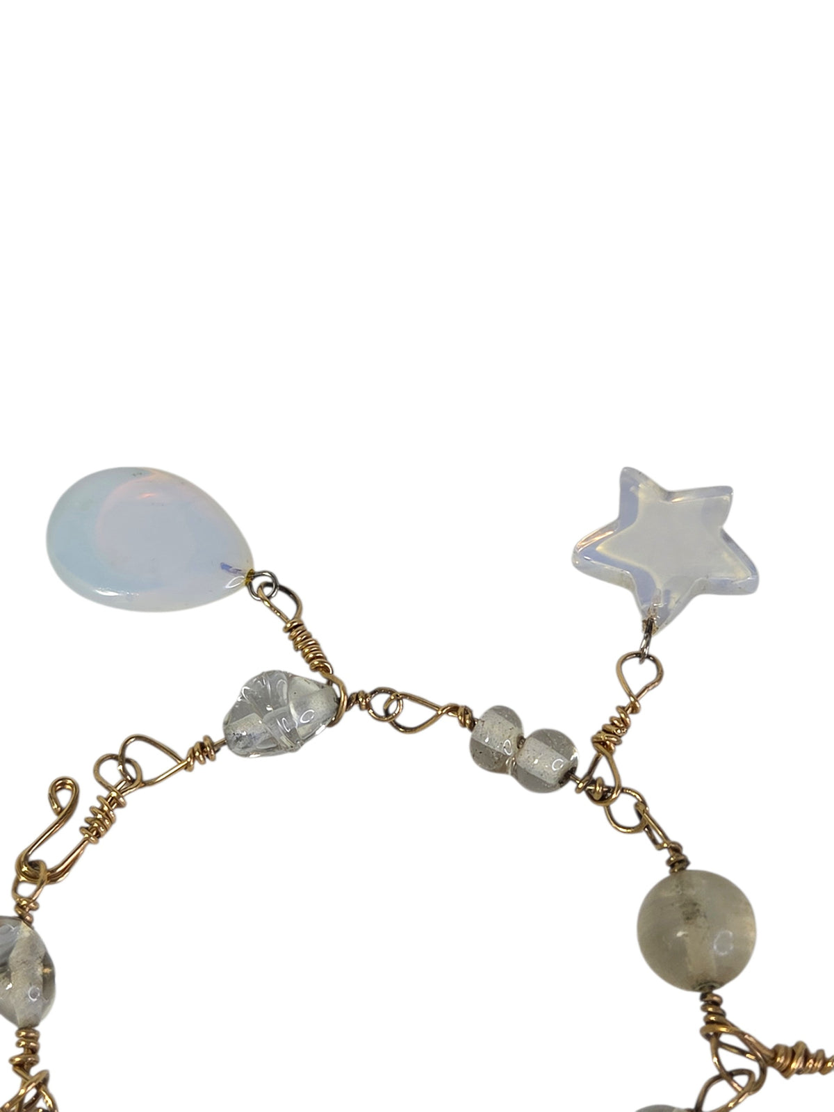 Close-up of the opalite teardrop and star charms glowing blue and peach, with silver-tone jump rings
