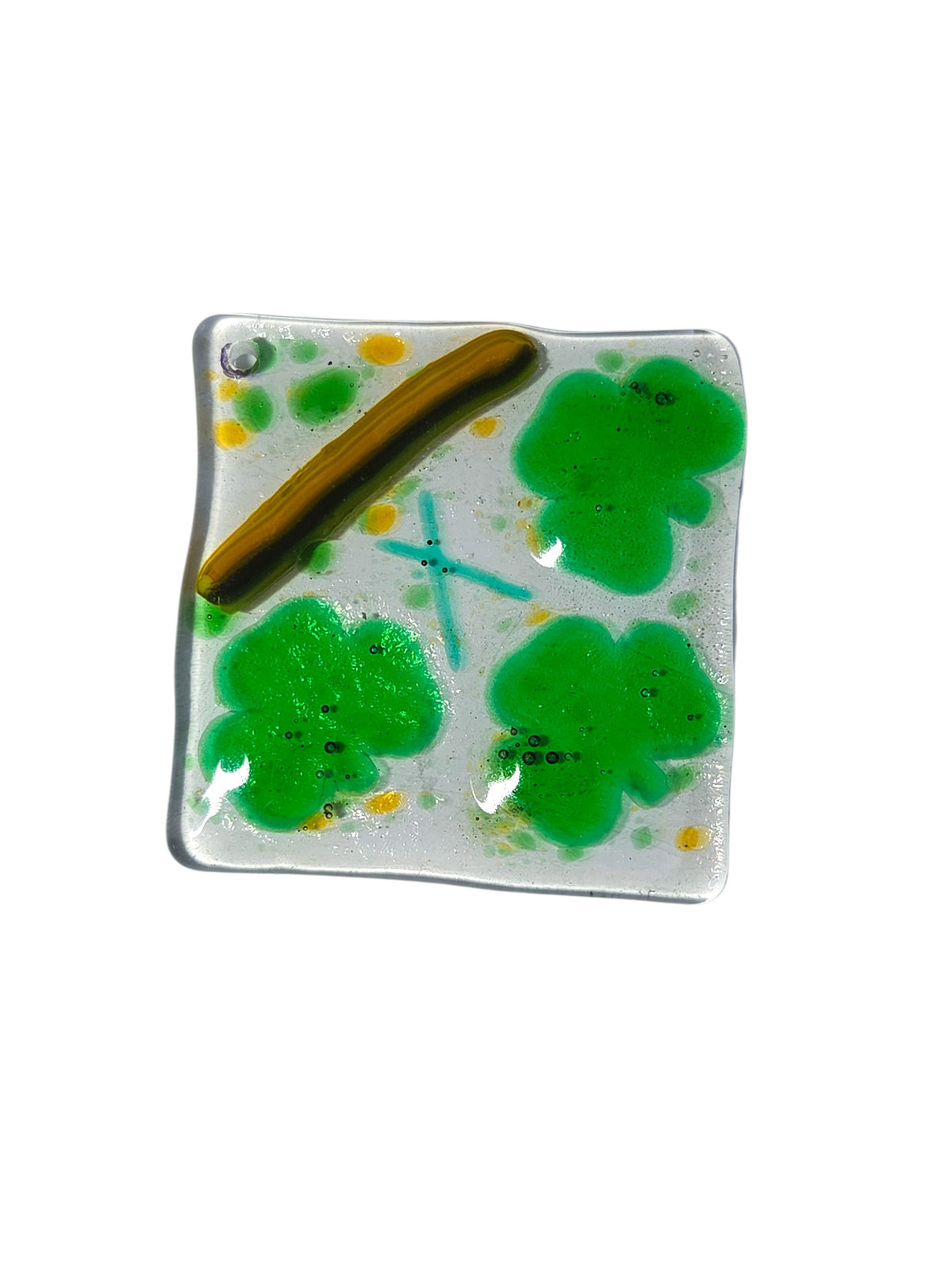 Yellow swirled fused glass suncatcher with a glittery dark green dichroic shamrock on a green ribbon