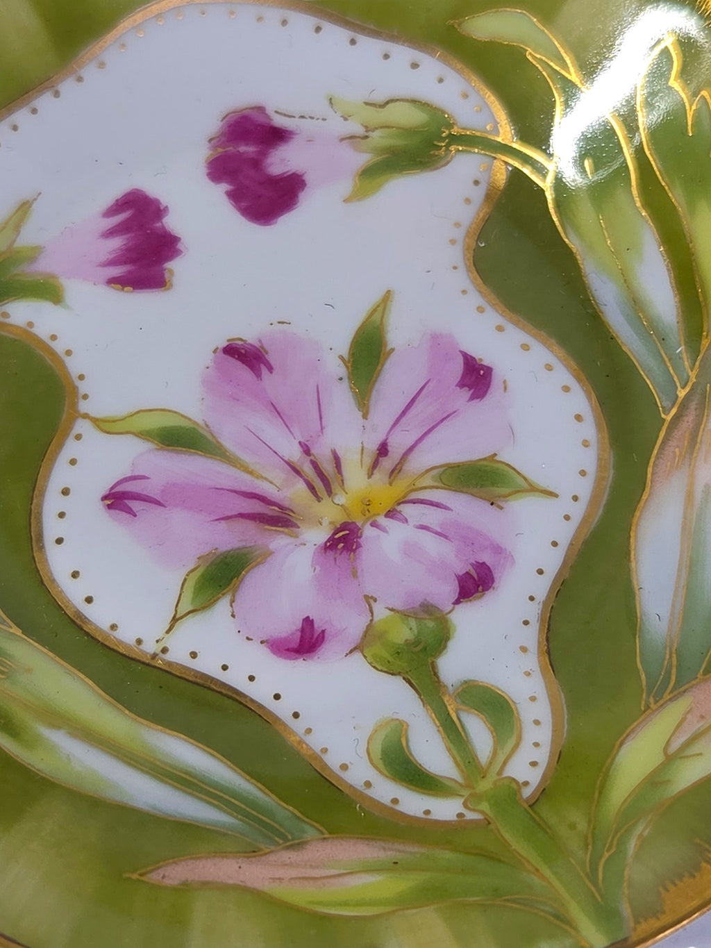 Close-up of the hand painted pink flower, magenta buds and fine gold outlining on the porcelain dish