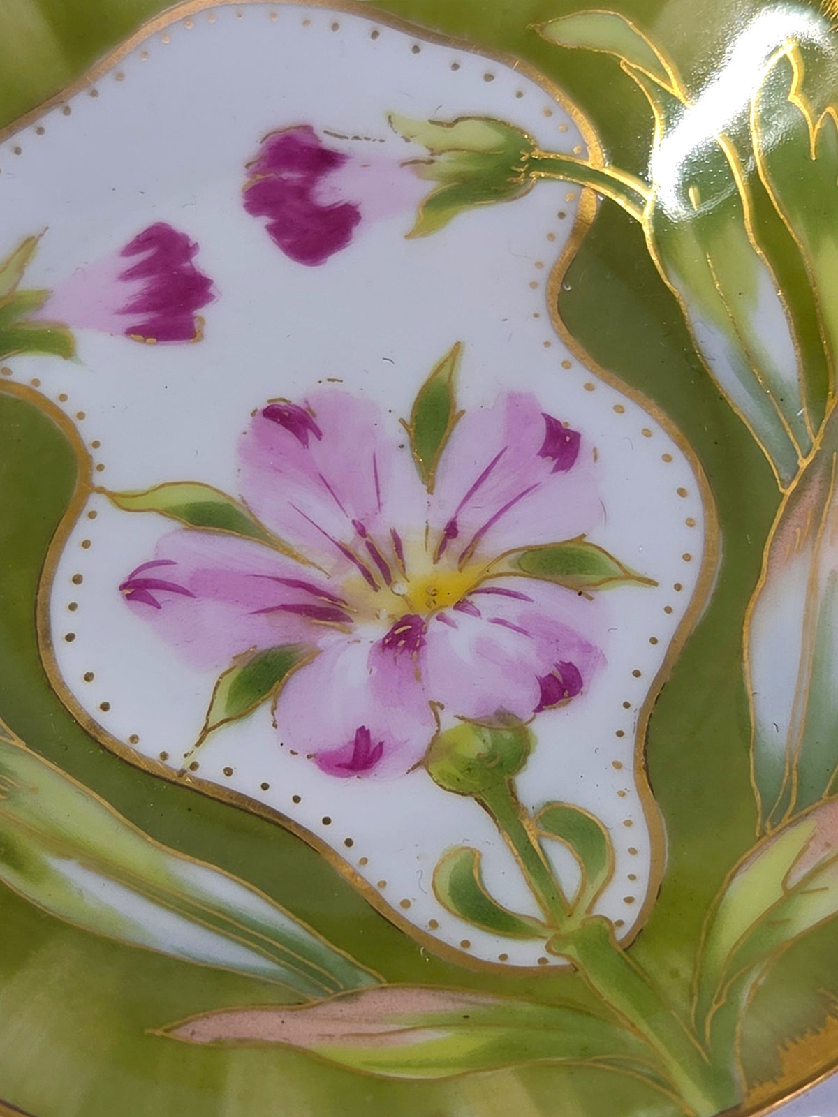 Close-up of the hand painted pink flower, magenta buds and fine gold outlining on the porcelain dish