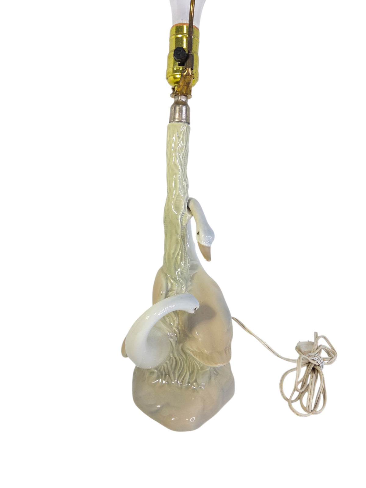 Side of the porcelain swan lamp showing the arched neck of the upper swan and the textured bark trunk