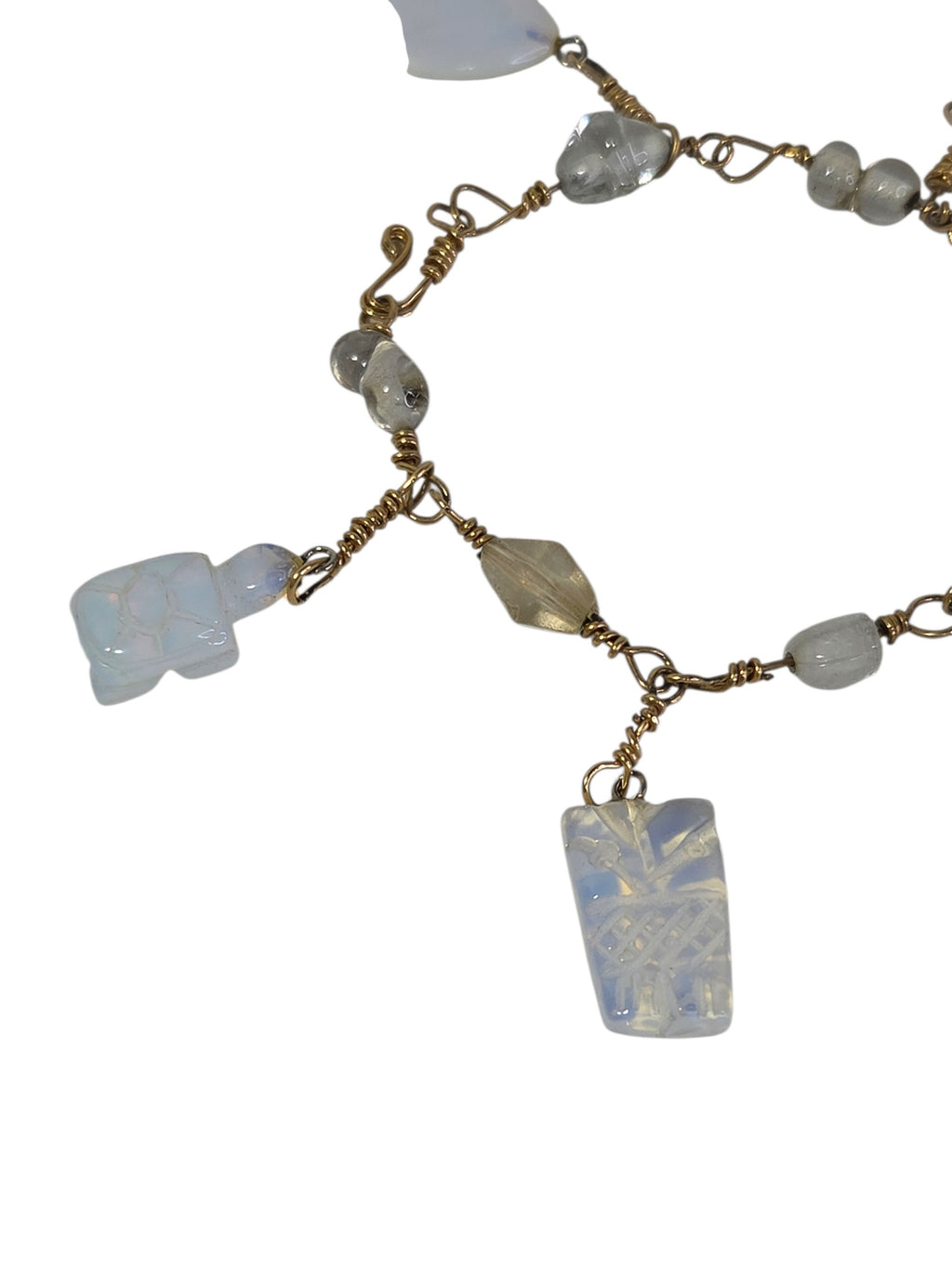 Close-up of the carved opalite turtle and pineapple charms with a champagne faceted glass bead on gold-tone wire