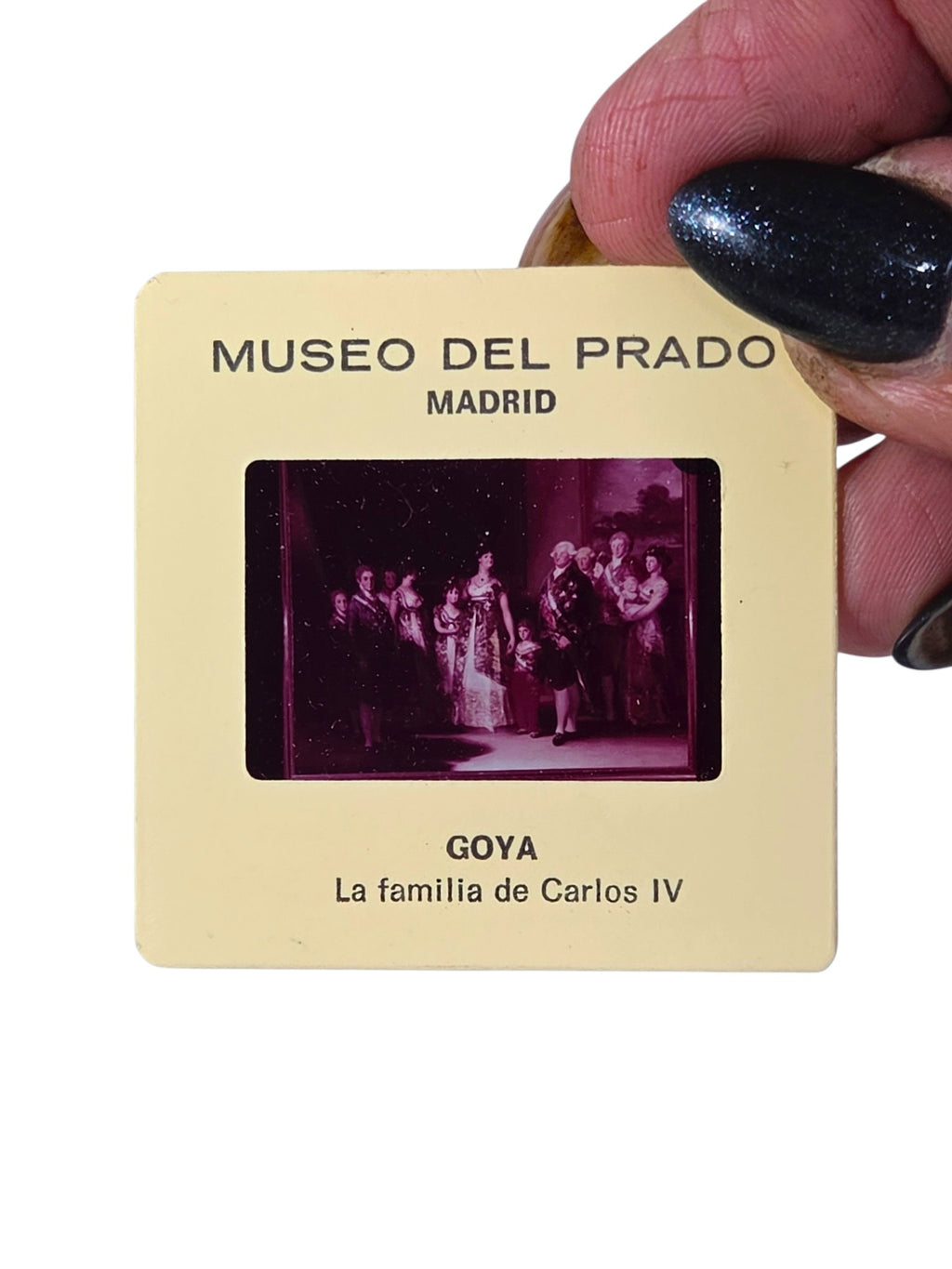 Museo del Prado souvenir slide of Goya's La familia de Carlos IV held in hand, magenta-toned royal family portrait in a cream mount