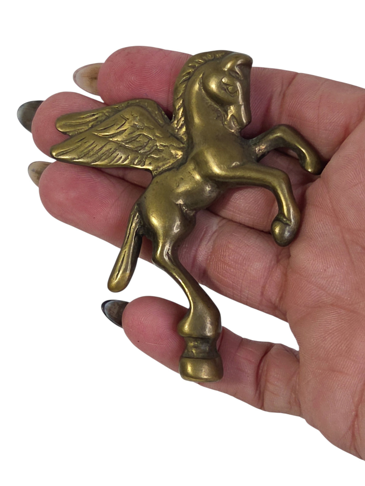 Solid brass Pegasus finial held in a hand to show its small size
