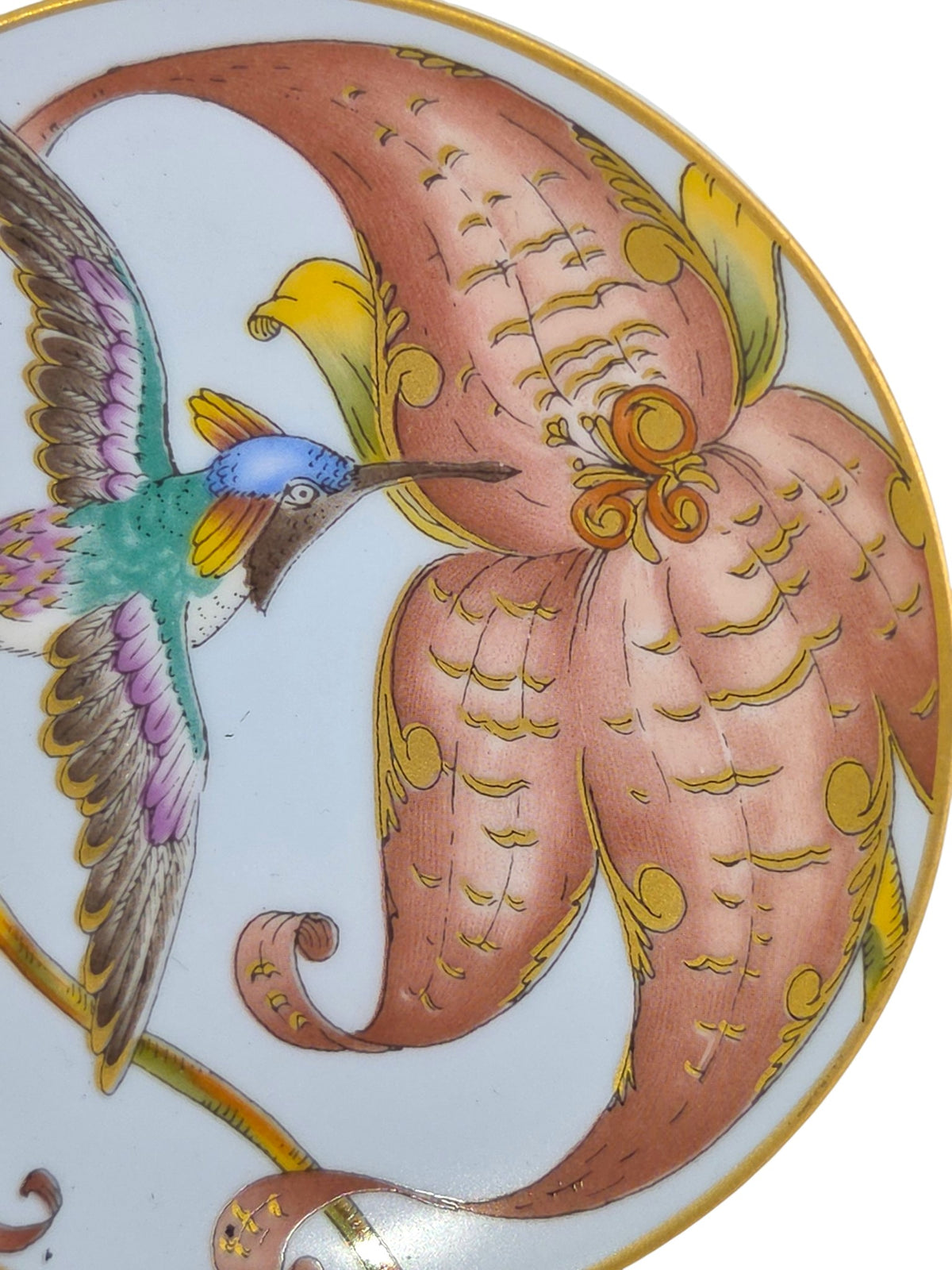 Close-up of the coral lily with raised gold scrolls and the hummingbird's blue crown and gold tufts