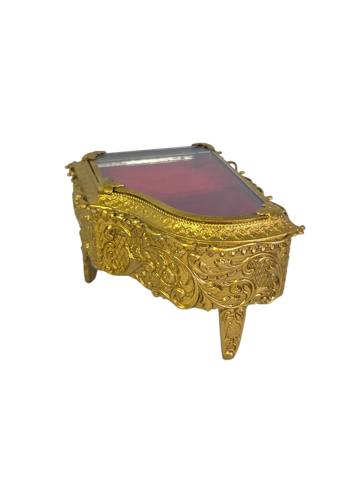 Side view of the ormolu piano jewelry box showing embossed roses, lattice and scrolls and the curved legs
