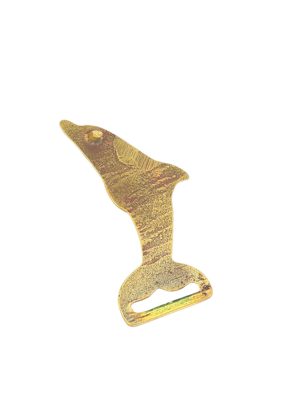 Brass dolphin belt buckle at an angle showing the fin, red-tinted eye and cast texture along the body