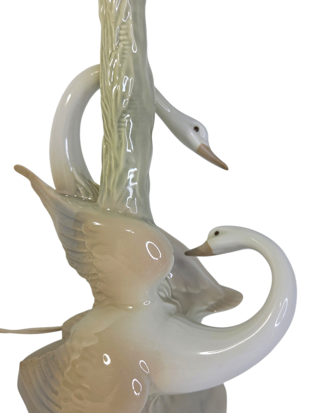 Porcelain swan lamp from the back, showing both swan heads with peach beaks and the turn-key socket