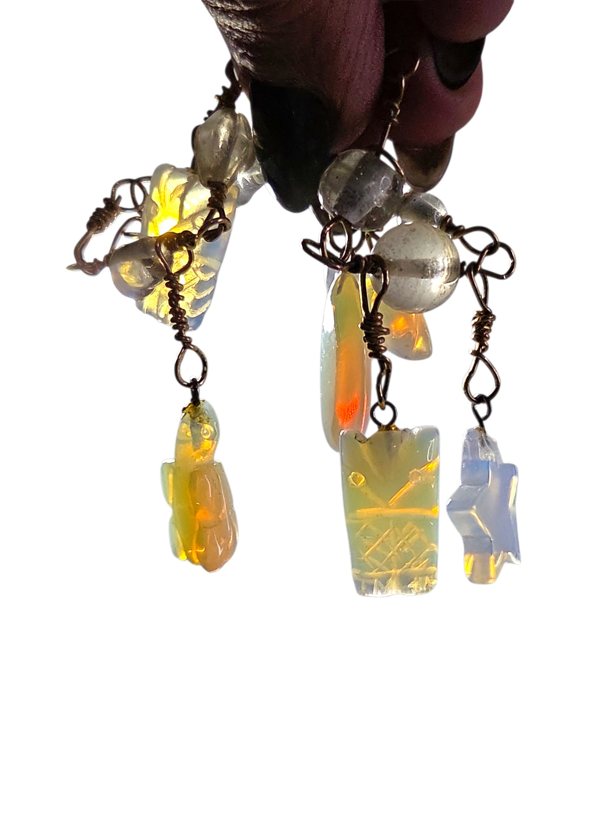 Detail of the carved opalite charms showing the opalescent blue glow