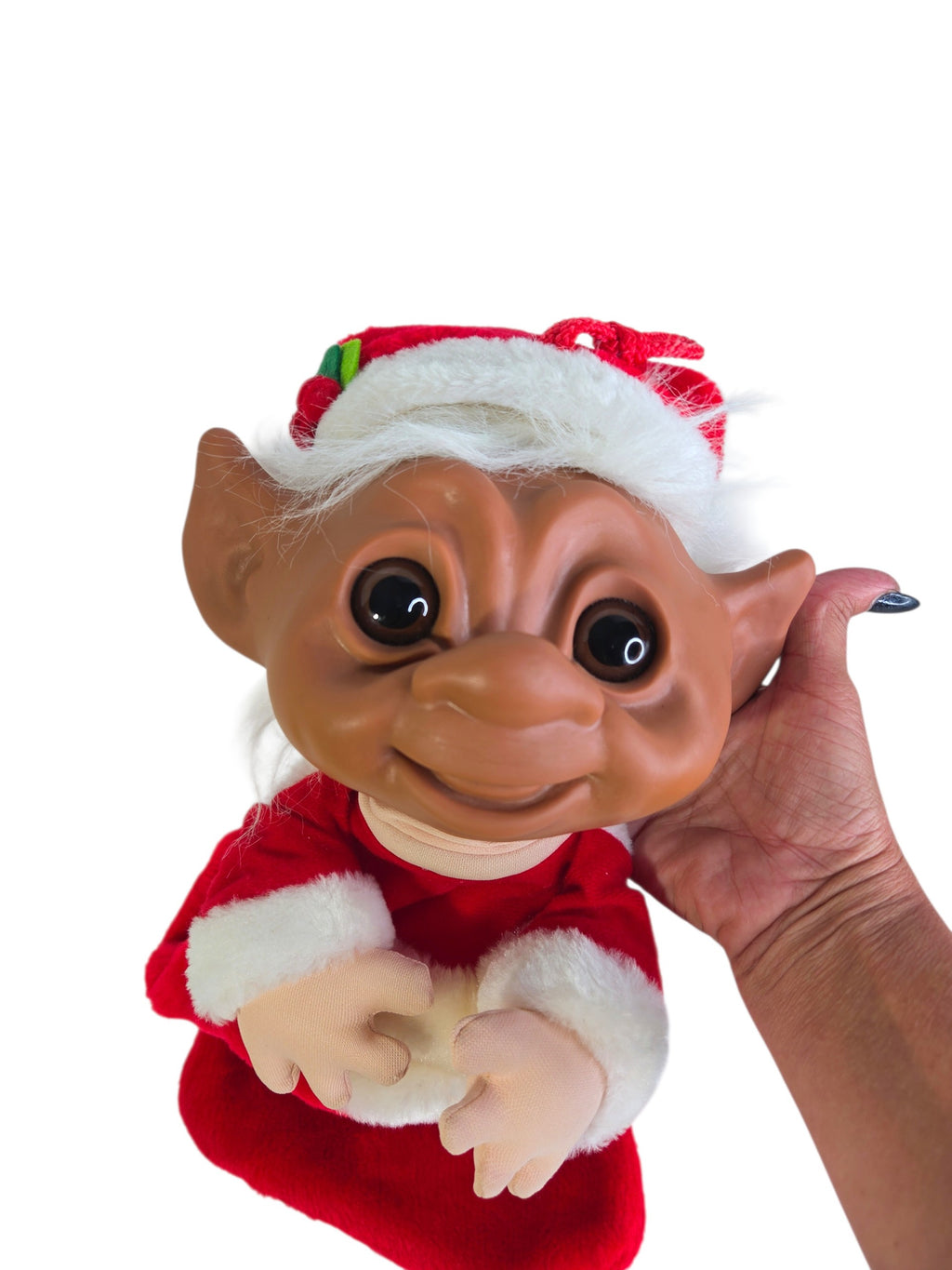 Side profile of the troll's vinyl face with pointy ear, white plush hair and holly on the Santa hat