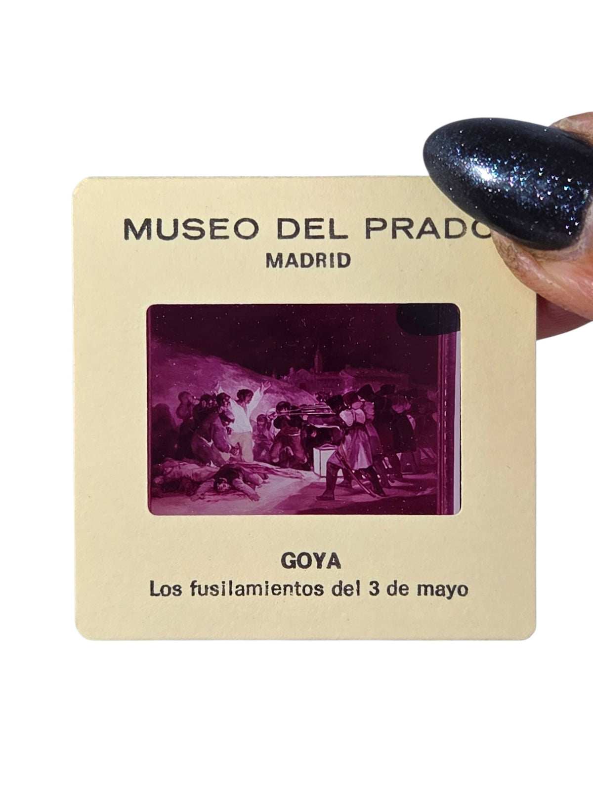 Museo del Prado souvenir slide of Goya's Los fusilamientos del 3 de mayo, The Third of May 1808, held in hand, magenta-toned image