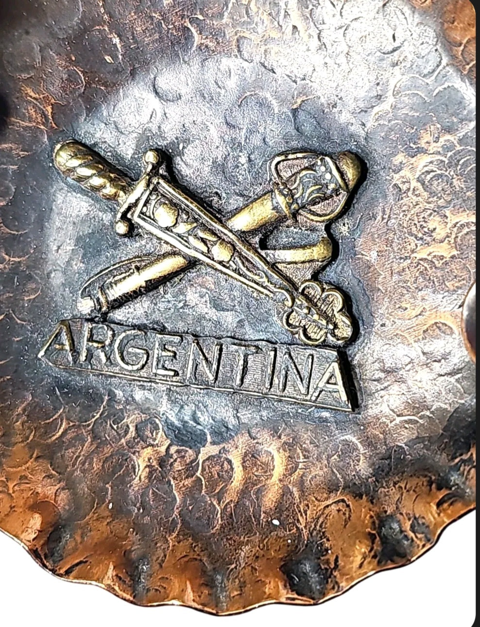 Oddly Darling Vintage hand-hammered copper ashtray with a raised brass Argentina emblem and crossed swords design.