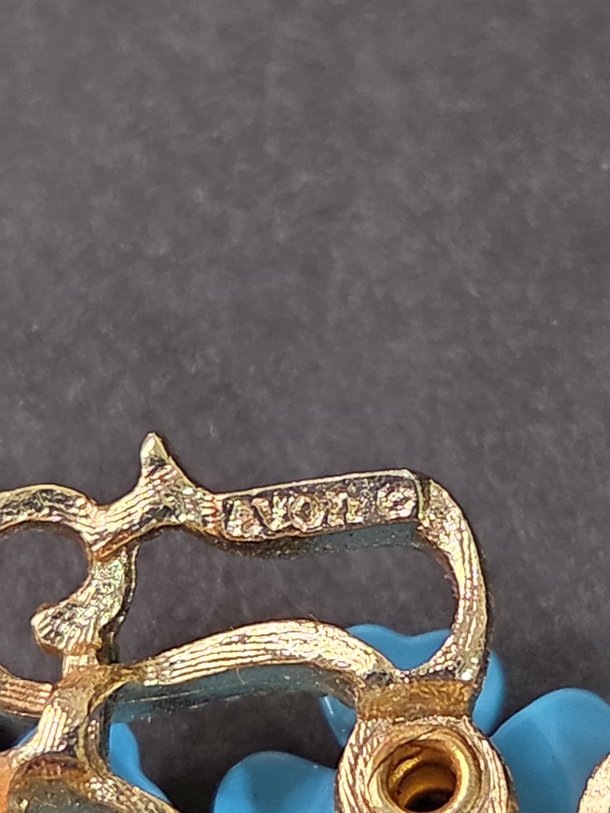 Oddly Darling Vintage AVON floral brooch showing the signature stamp on the gold-tone filigree metal backing
