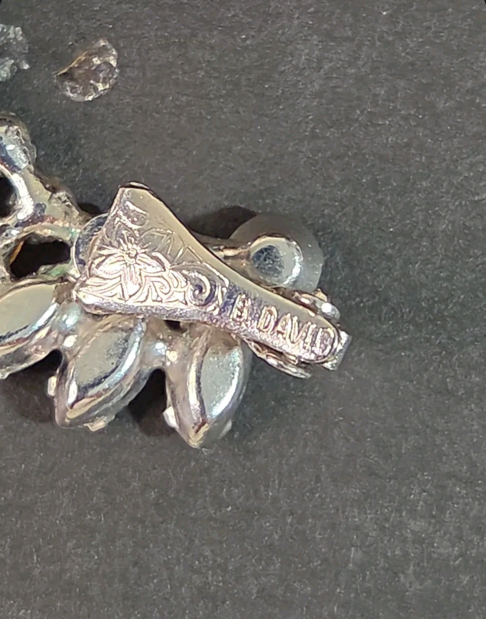Oddly Darling Vintage B. David clip-on earring back showing floral engraving and signature hallmark on silver-tone metal