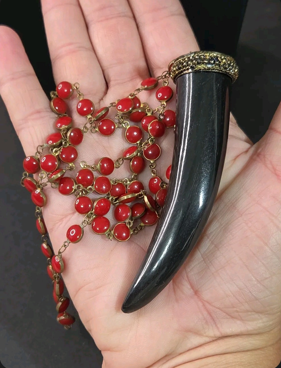 Oddly Darling Vintage long necklace with a black tusk pendant, gold-tone cap, and vibrant red circular enamel beads.