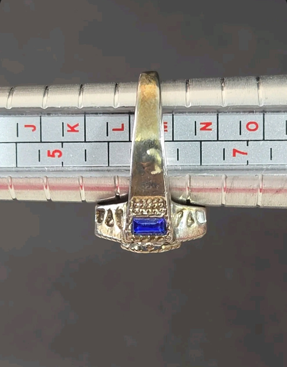 Oddly Darling Vintage ornate statement ring with a blue baguette stone on a metal ring sizing mandrel