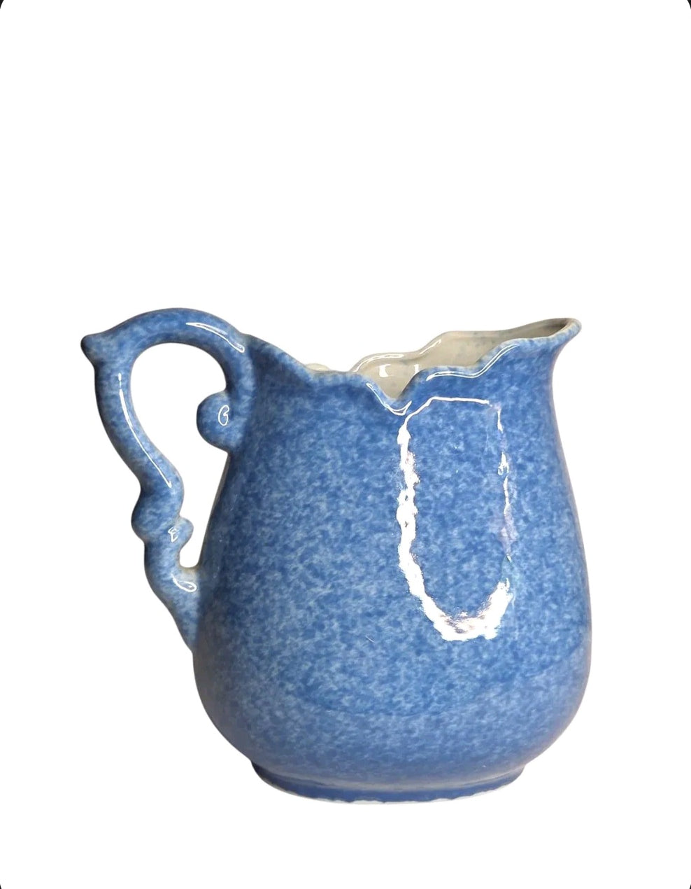 Oddly Darling Vintage ceramic pitcher with a mottled blue sponge-ware glaze, scalloped rim, and ornate handle.