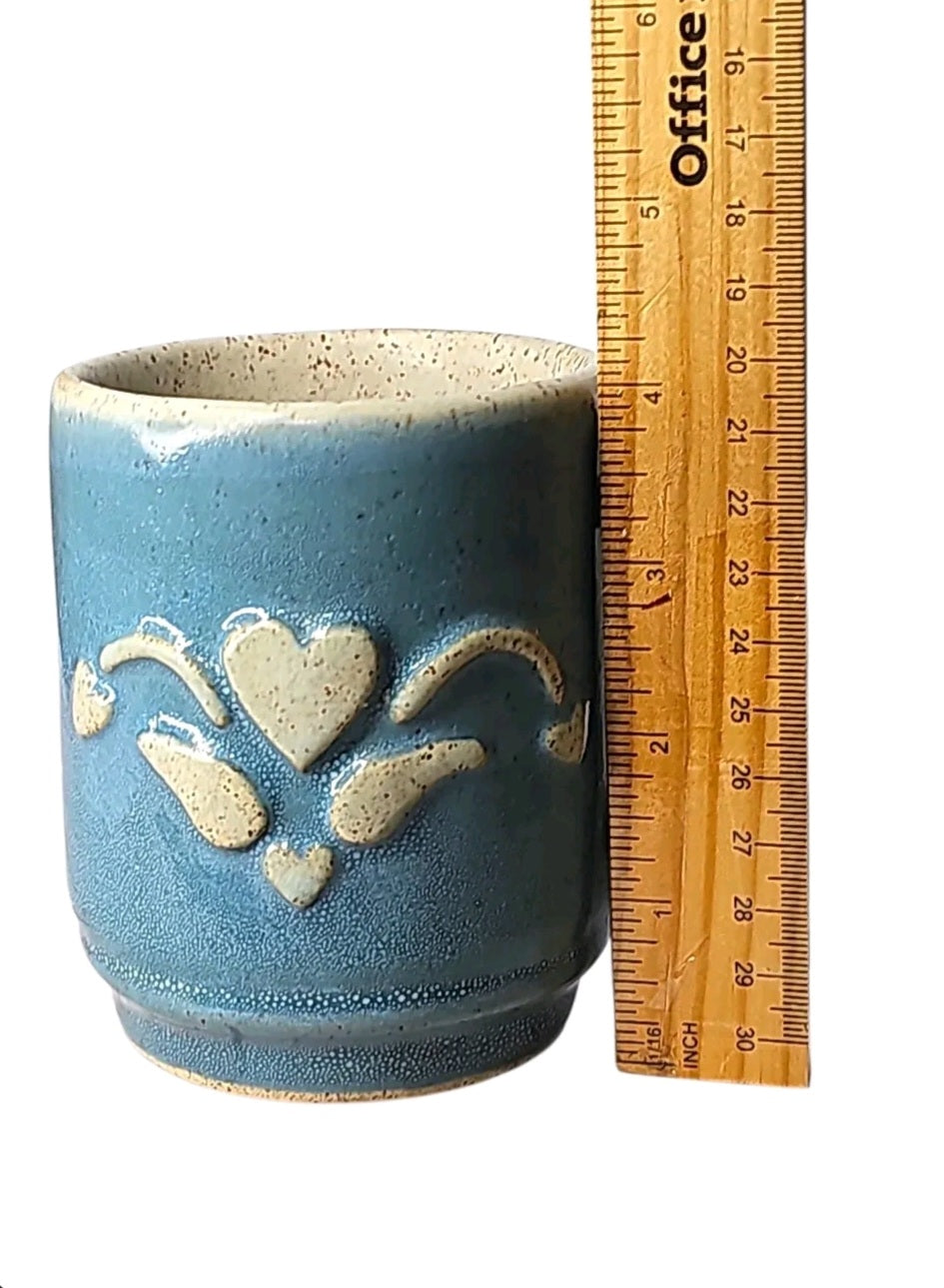 Oddly Darling Vintage handcrafted blue stoneware coffee mug with a raised heart motif and speckled cream interior.