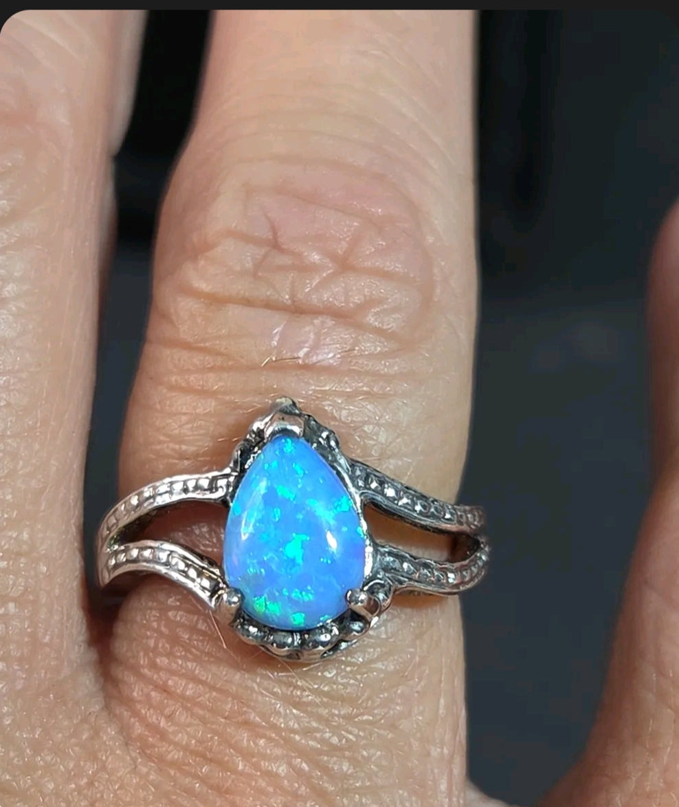 Oddly Darling Vintage pear-shaped blue opal statement ring with a textured silver split-shank band on a finger.