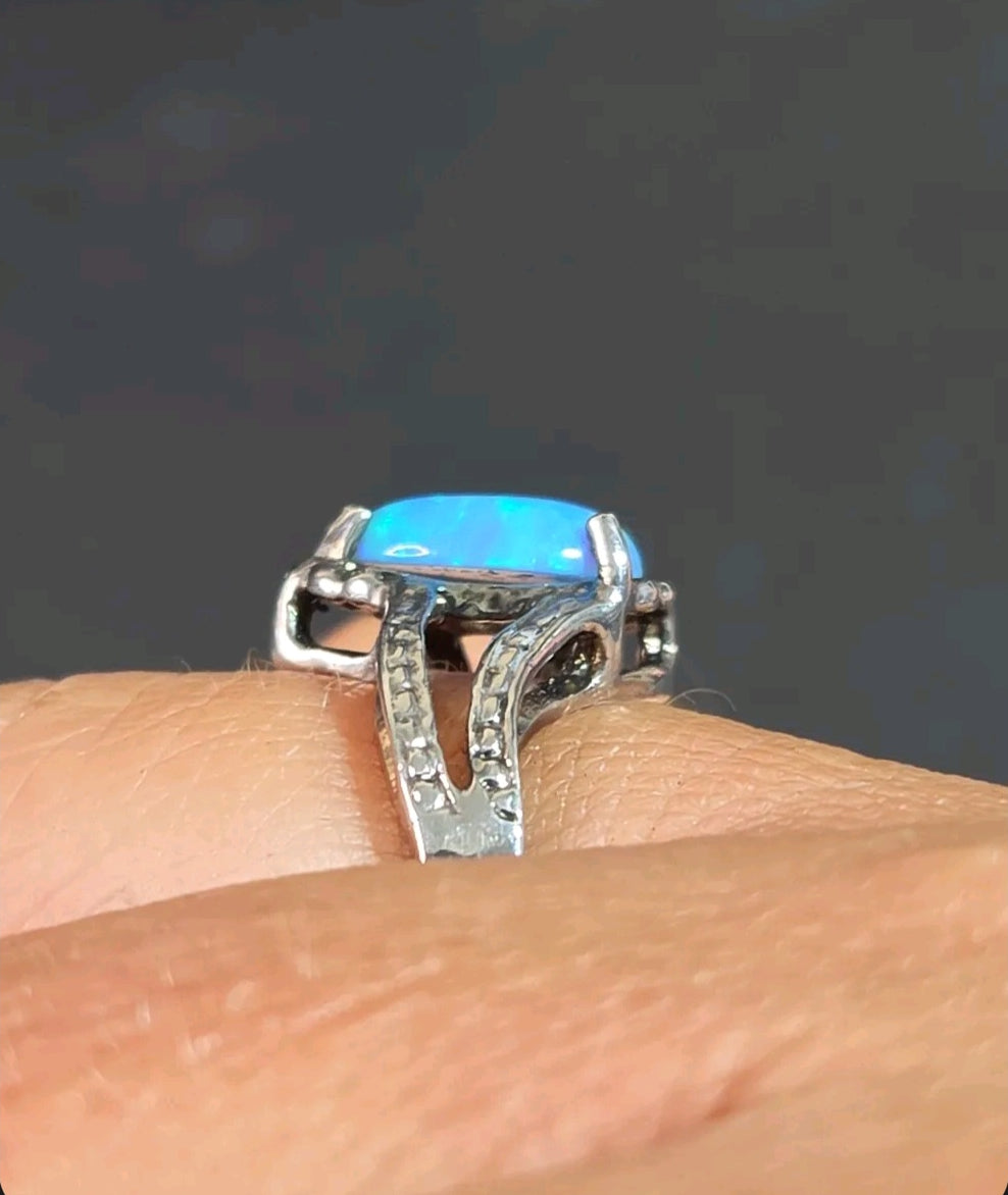 Oddly Darling Vintage pear-shaped blue opal statement ring with a textured silver-tone split-shank band on a finger.