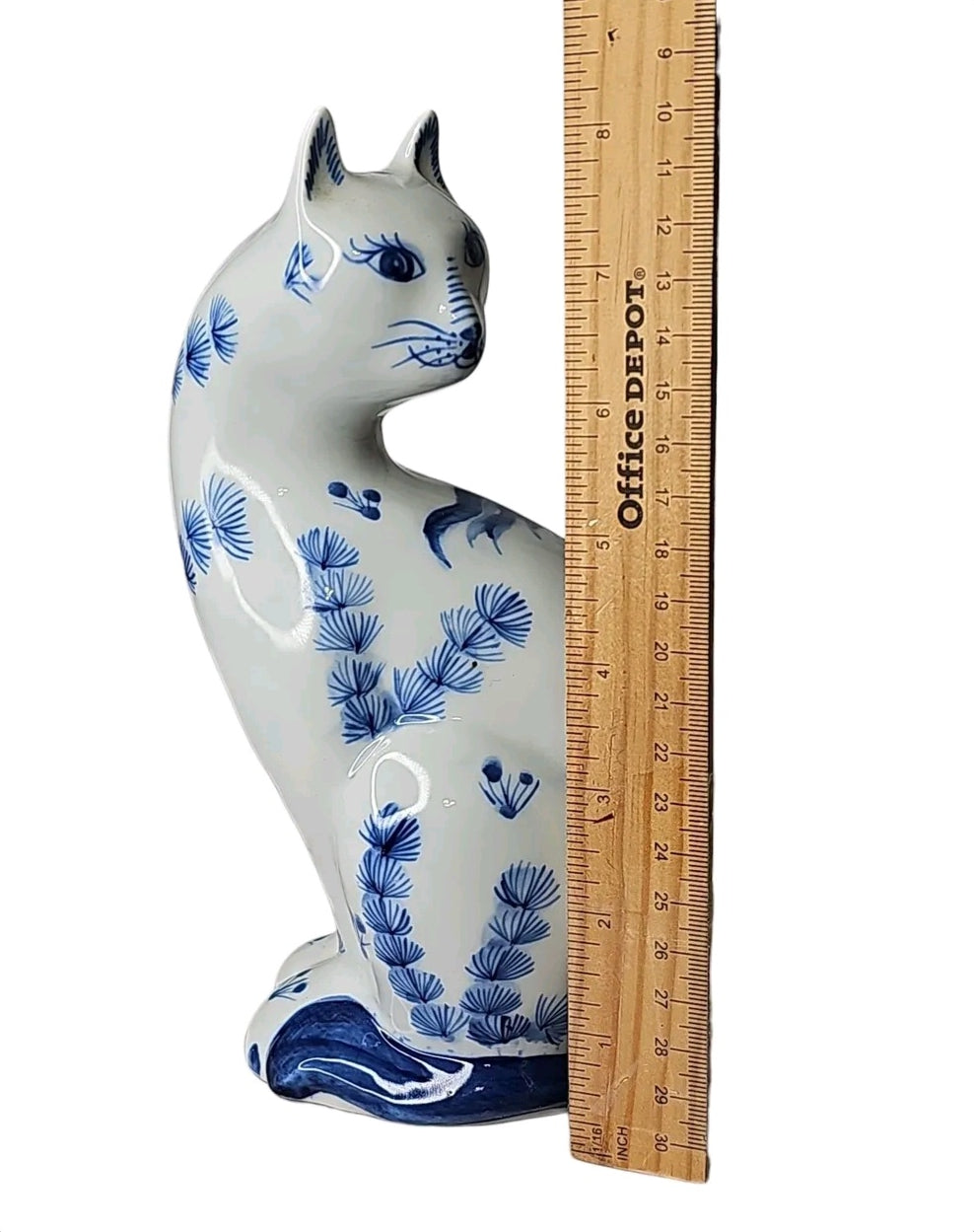 Oddly Darling Vintage blue and white ceramic cat figurine with hand-painted botanical motifs next to a ruler