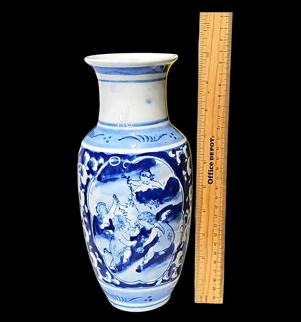 Oddly Darling Vintage blue and white ceramic vase featuring hand-painted cherub motifs and floral scrollwork