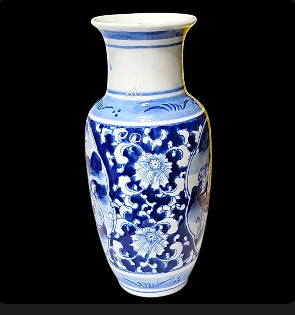 Oddly Darling Vintage blue and white ceramic vase featuring intricate hand-painted floral scrollwork and cherub motifs.