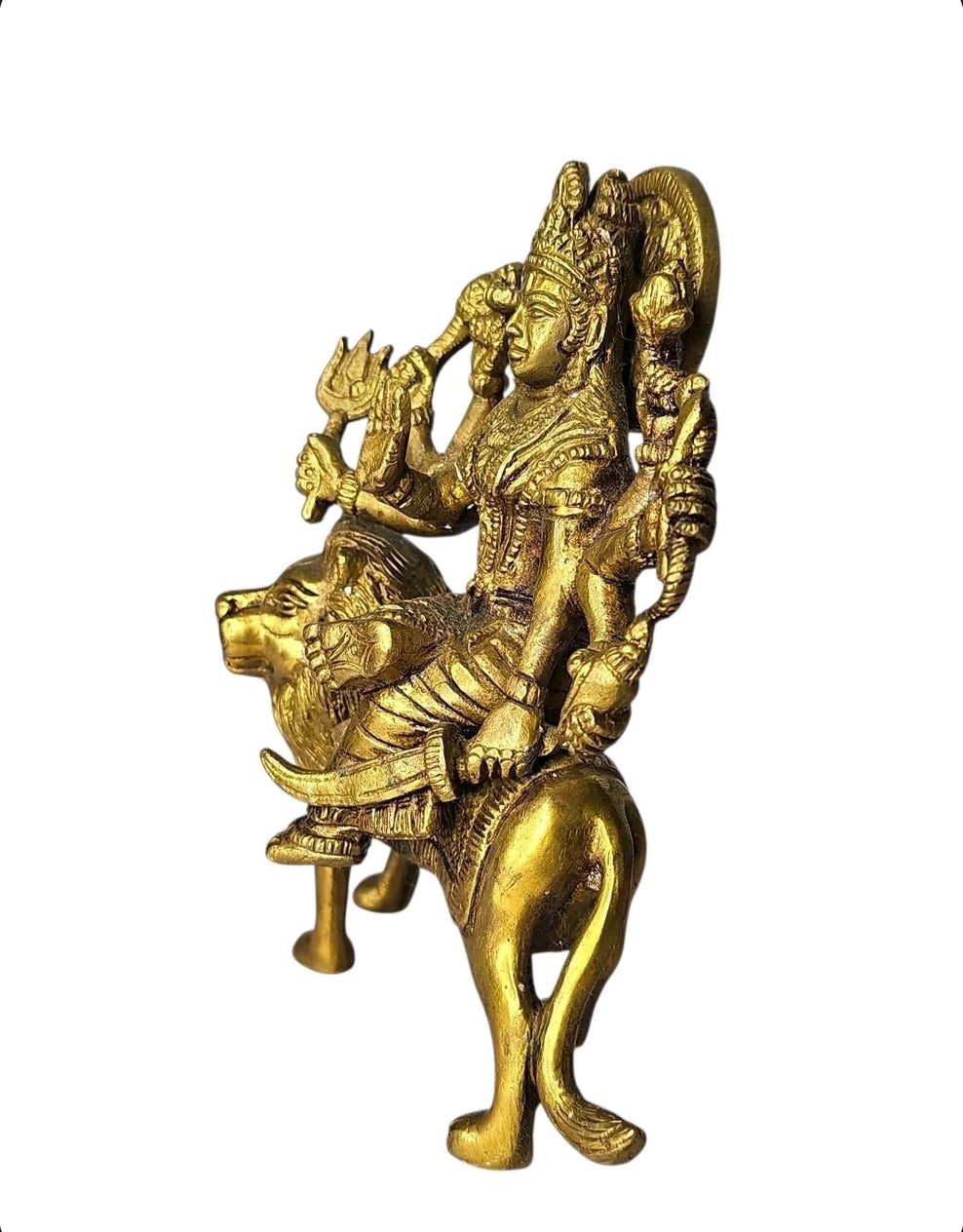 Oddly Darling Vintage handcrafted brass Goddess Durga statue riding a lion with intricate gold-toned carvings.