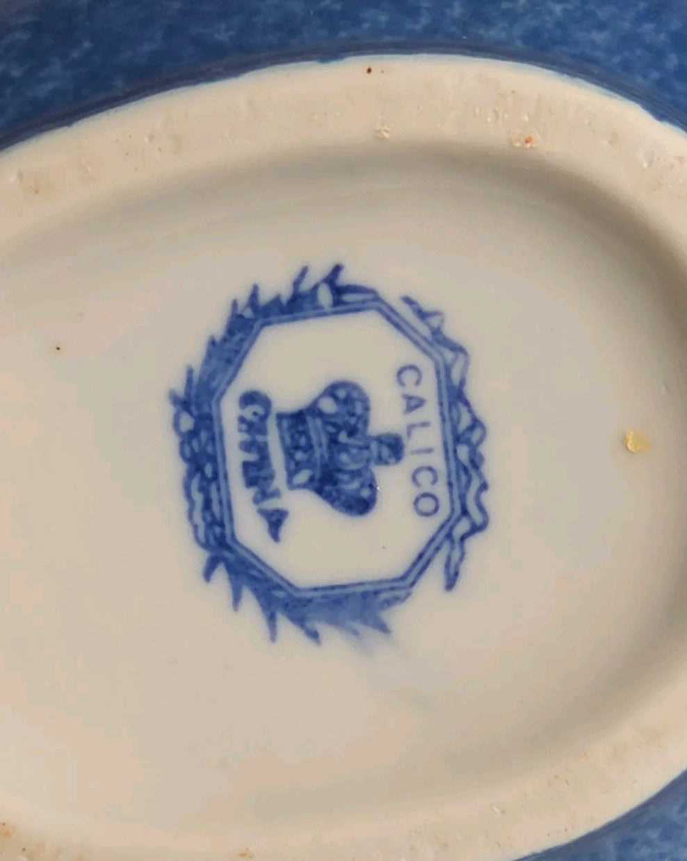 Oddly Darling Vintage Calico China maker mark on the base of a blue ceramic pitcher with a crown and wreath logo