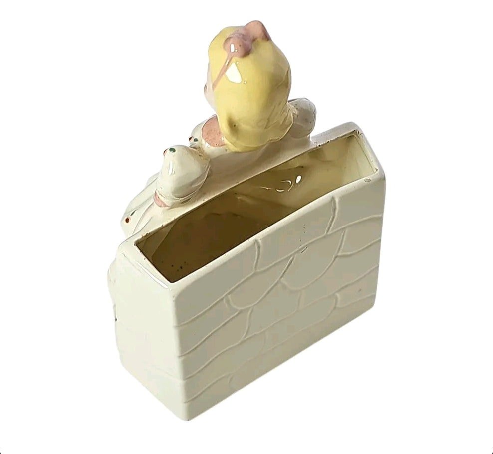 Close-up of hand-painted face and blonde hair on vintage girl planter