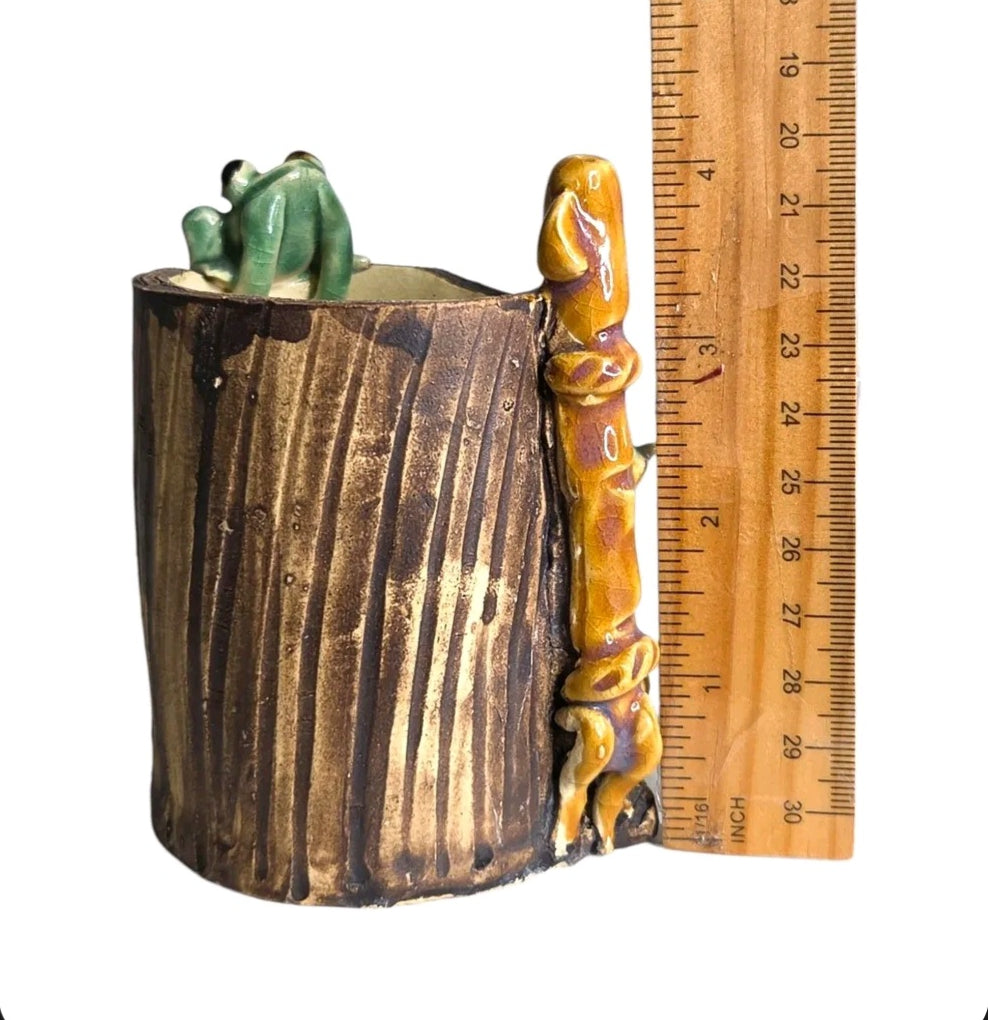 Oddly Darling Vintage handcrafted ceramic tree stump vessel with a green frog and bamboo accent next to a ruler.