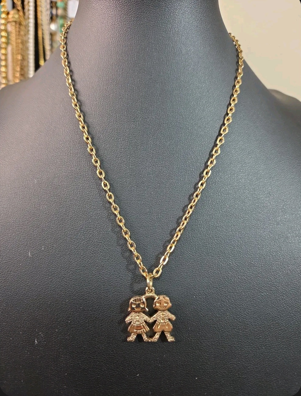 Oddly Darling Vintage gold-tone necklace featuring a pendant of two children holding hands on a delicate chain.