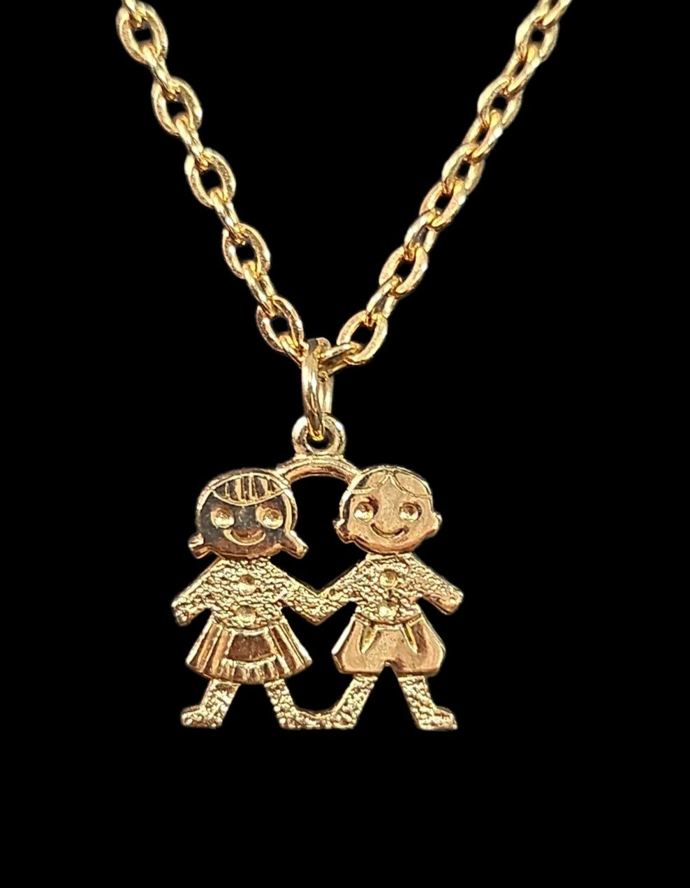 Oddly Darling Vintage gold-tone necklace featuring a pendant of two children holding hands with textured detailing.
