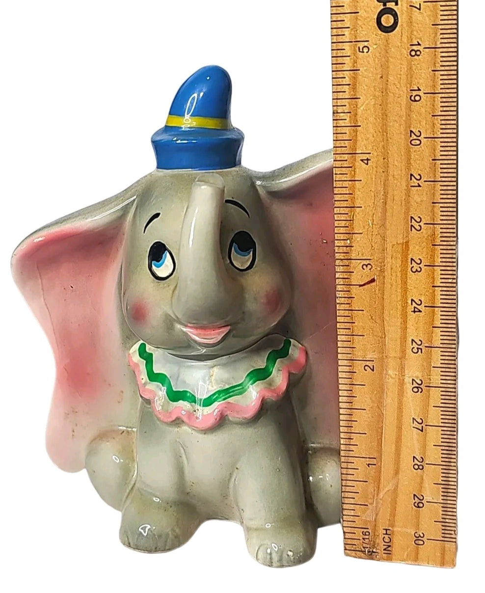 Oddly Darling Vintage ceramic Dumbo figurine with blue hat and ruffled collar next to a wooden ruler for scale.