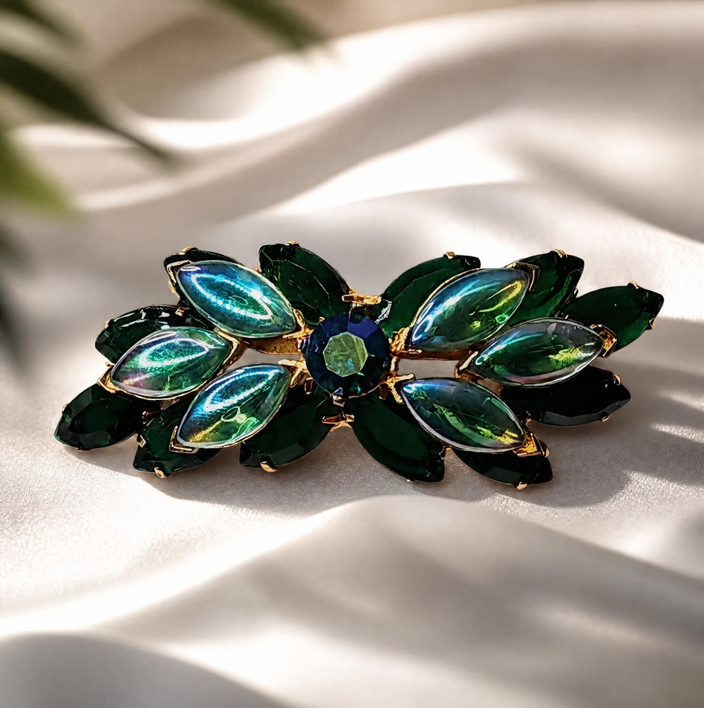 Oddly Darling Vintage brooch featuring emerald green marquise stones and a central round gem in polished gold-tone metal
