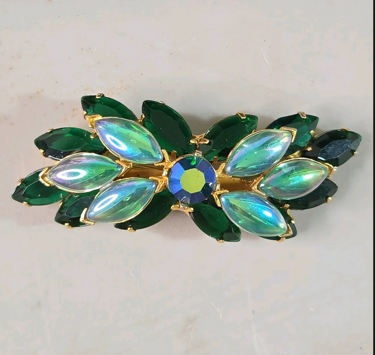 Oddly Darling Vintage brooch featuring emerald green marquise stones and iridescent accents in a gold-tone setting.