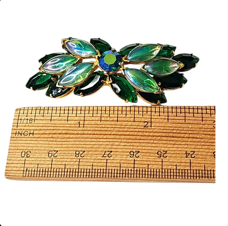 Oddly Darling Vintage emerald green marquise stone brooch with iridescent accents and gold-tone setting next to a ruler