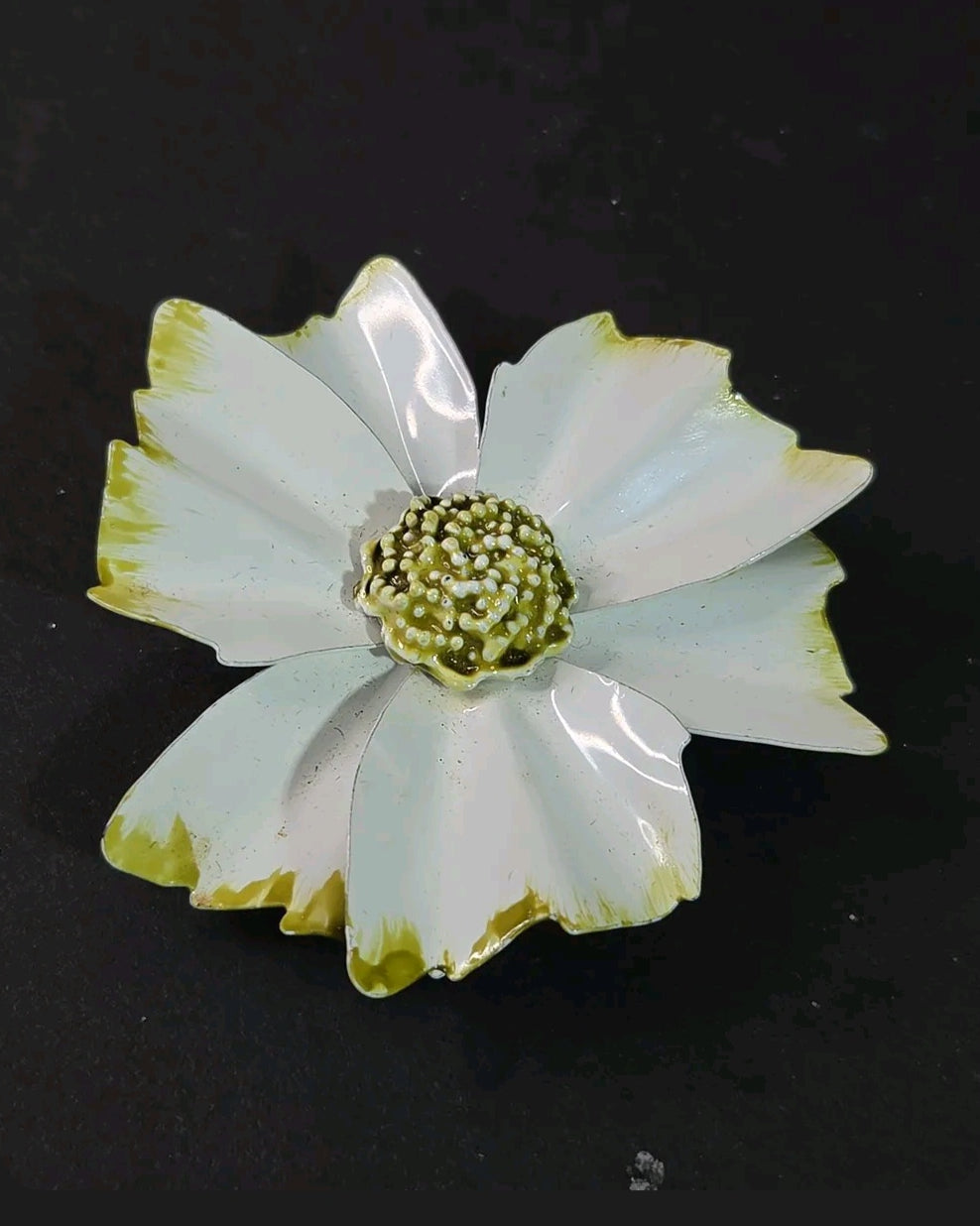 Oddly Darling Vintage enamel flower brooch with white petals, green tips, and a textured beaded center on black.