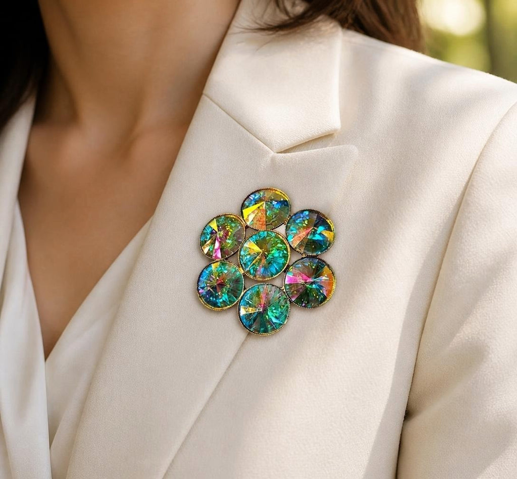 Oddly Darling Vintage floral cluster brooch with iridescent teal and gold crystals pinned to a cream blazer lapel.