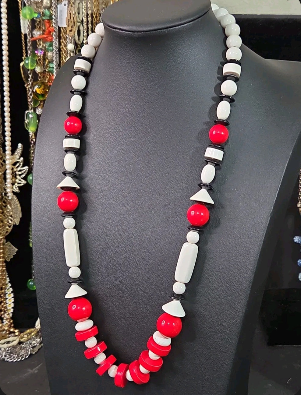 Oddly Darling Vintage geometric statement necklace featuring red, white, and black beads in various shapes on a bust.
