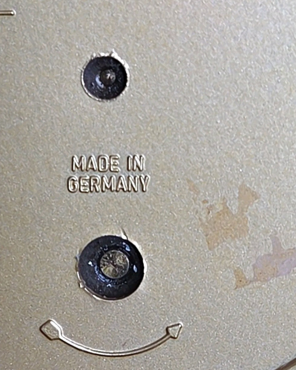 Oddly Darling Vintage mantel clock face detail showing Made in Germany engraving on a gold-toned metallic surface