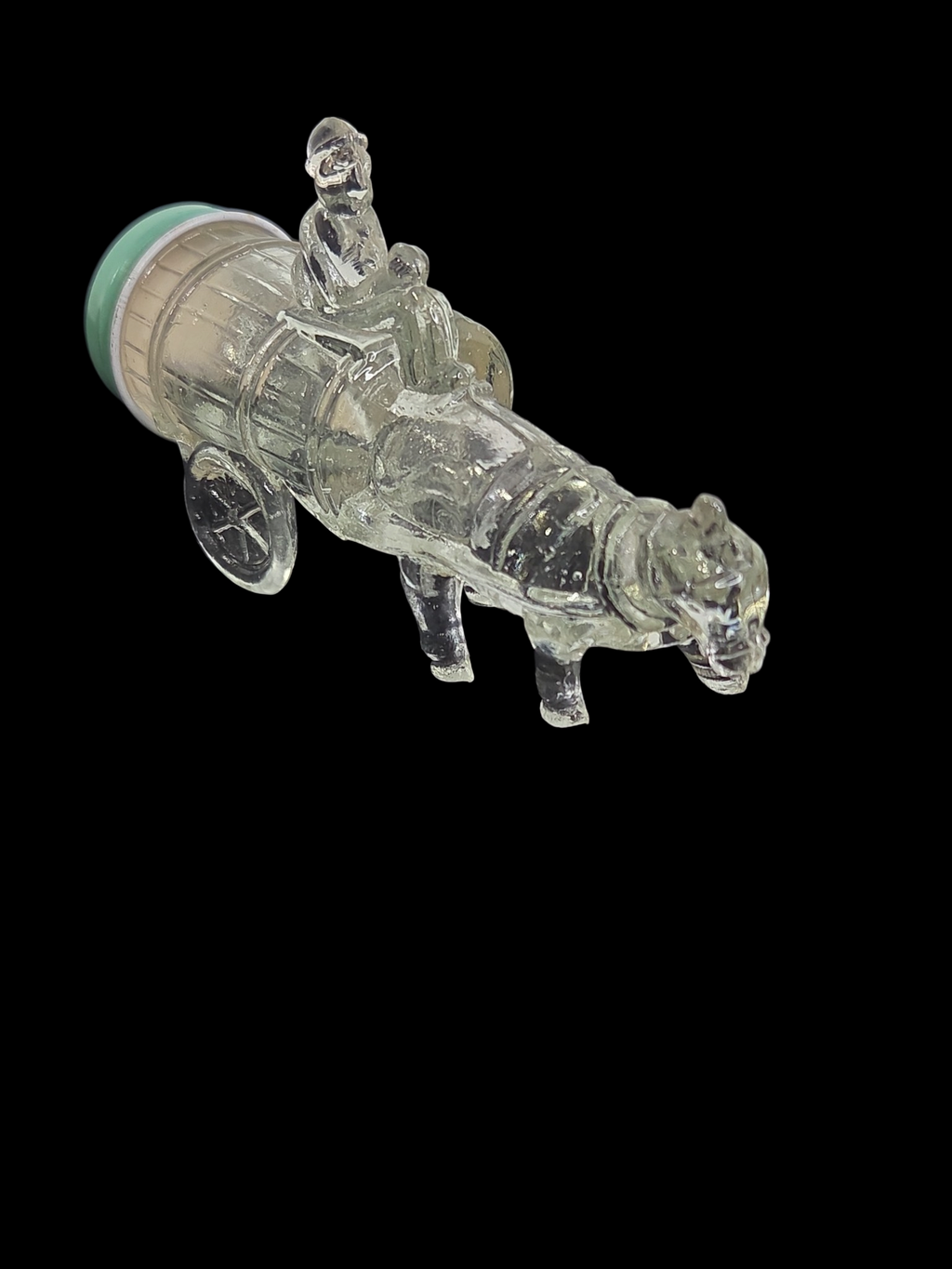Oddly Darling Vintage clear glass horse and cart decorative bottle with a light green lid on a black background.