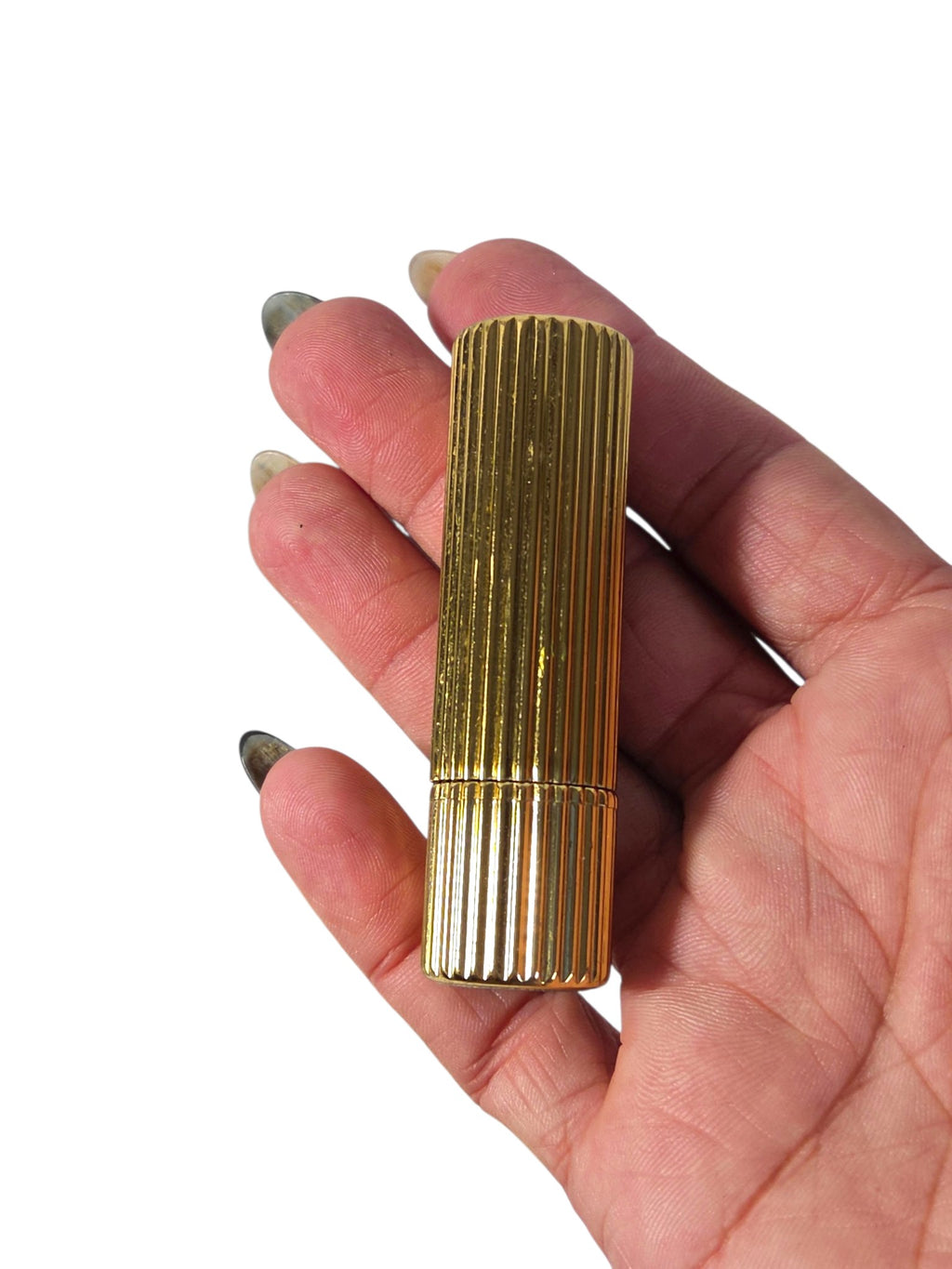 Estee Lauder ribbed gold-tone lipstick case held in hand