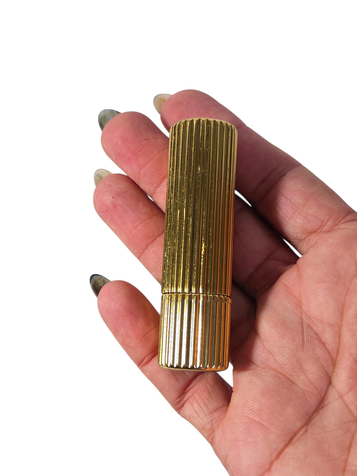 Estee Lauder ribbed gold-tone lipstick case held in hand