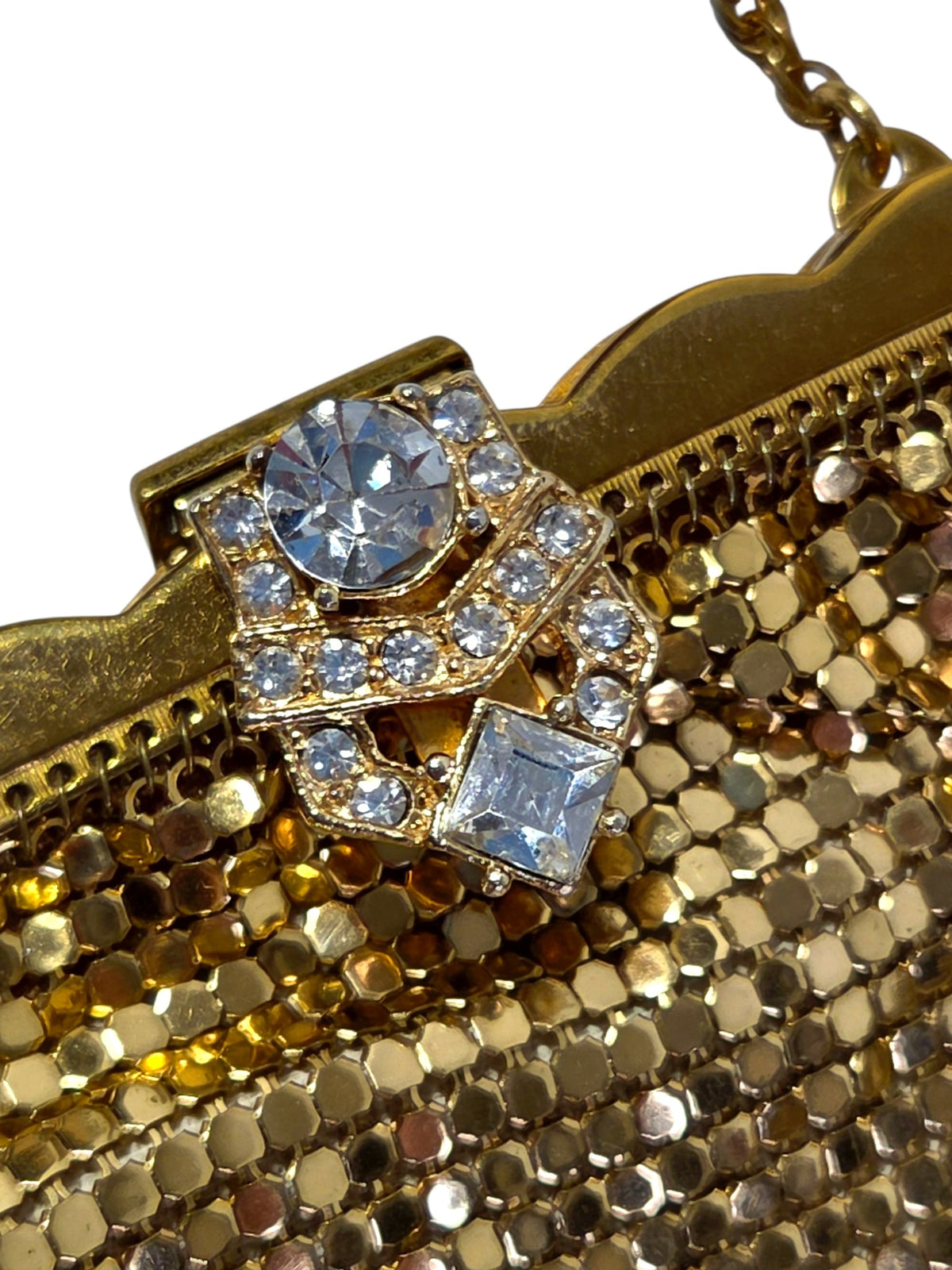 Angled close-up of the rhinestone clasp and scalloped gold-tone frame where the mesh hangs from it