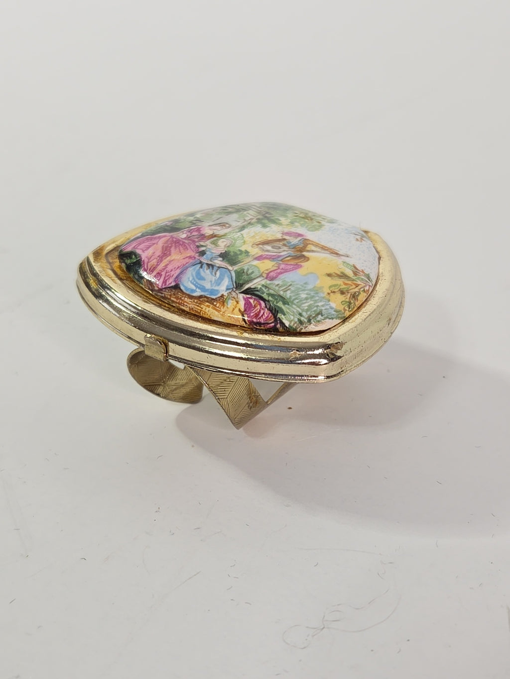 Oddly Darling Vintage gold-tone ring with a hinged lid featuring a colorful pastoral garden scene and internal mirror.