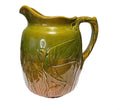 Large majolica style pitcher with embossed bird and cattails in green to brown glaze