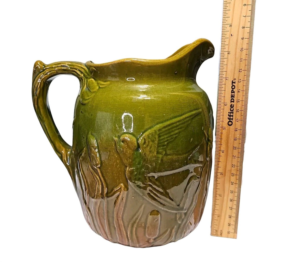 Majolica style pitcher with bird relief and twig handle