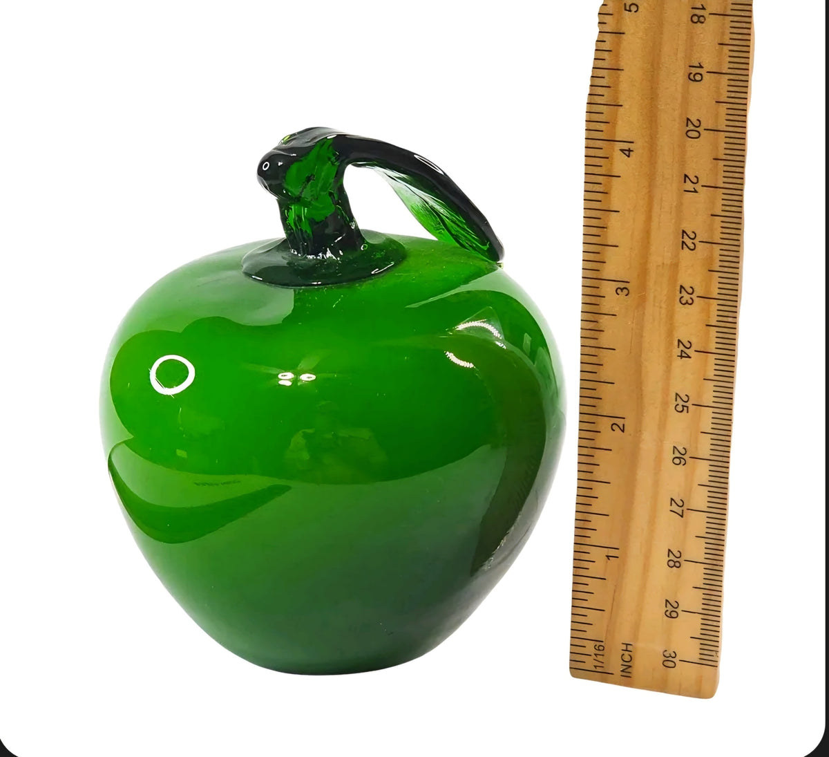 Oddly Darling Vintage hand blown green glass apple paperweight with dark green stem and leaf, shown with a ruler.